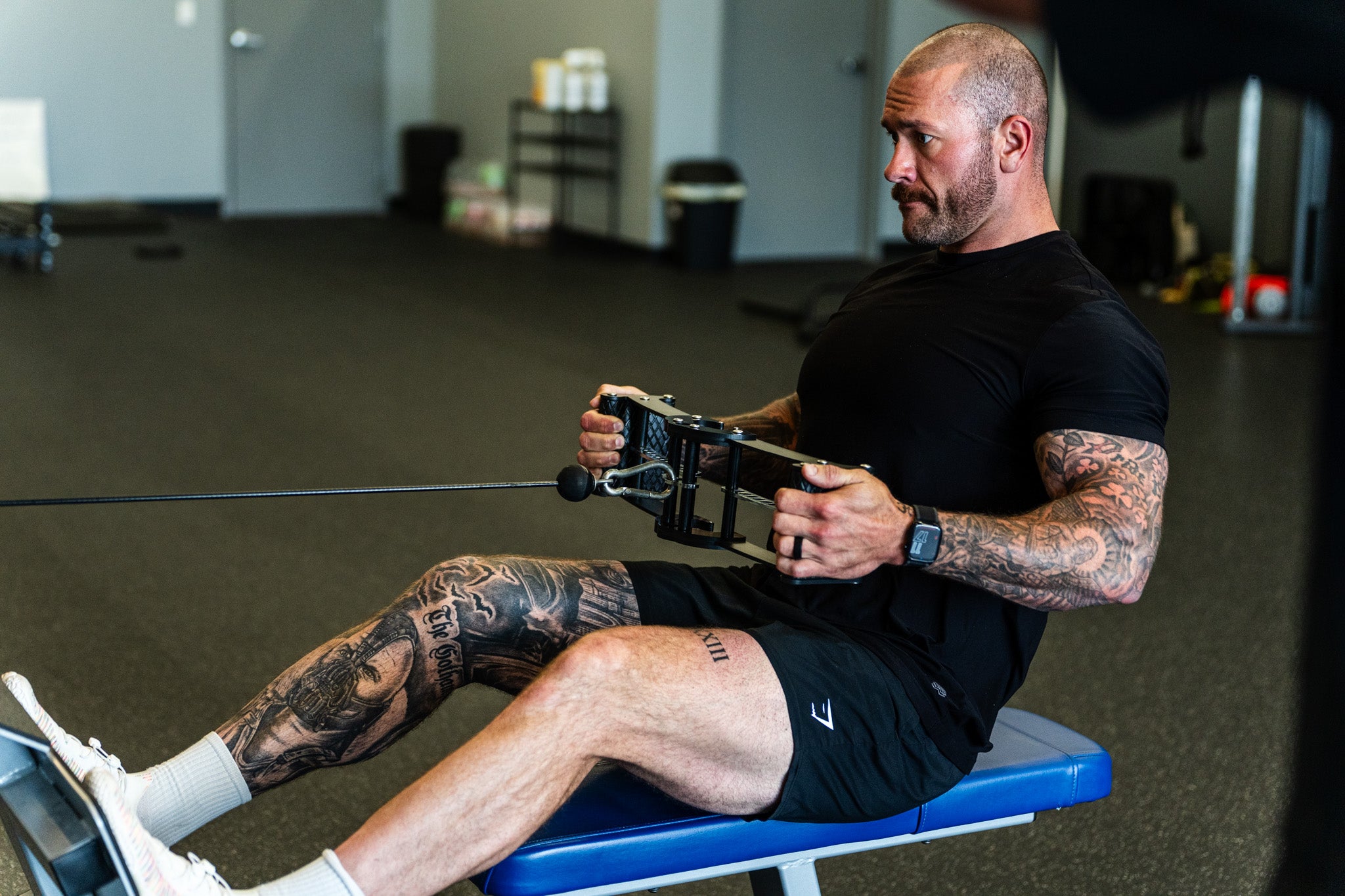 A lifter performing a seated cable row with the Back Bar in a gym