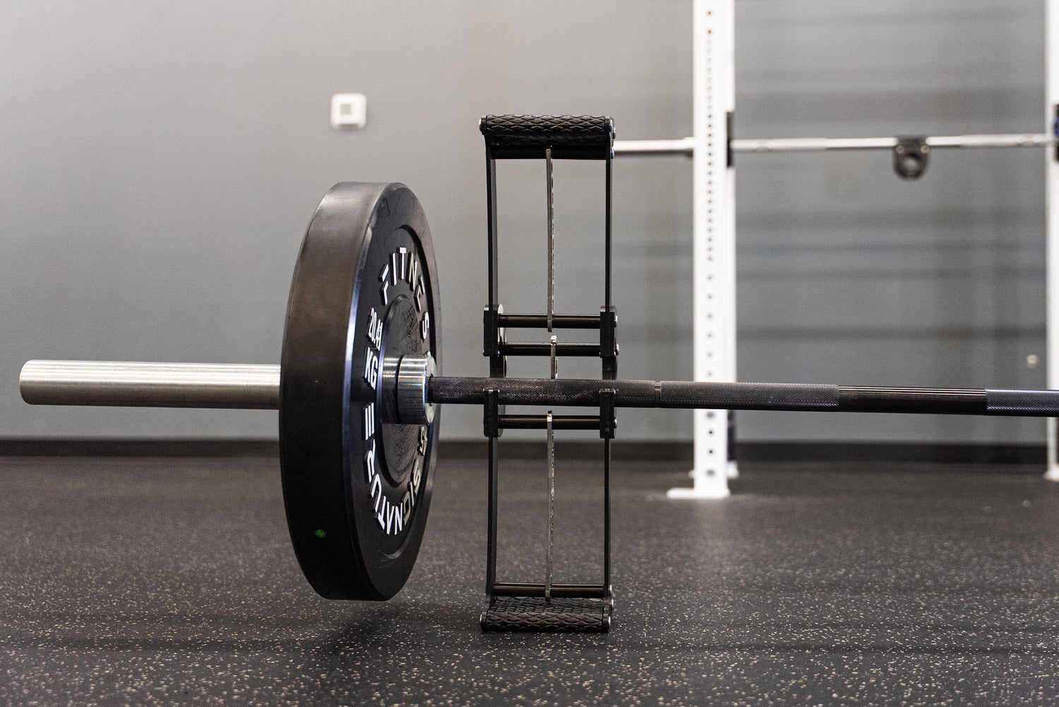 The Back Bar jacking a loaded barbell off the gym floor for a plate change