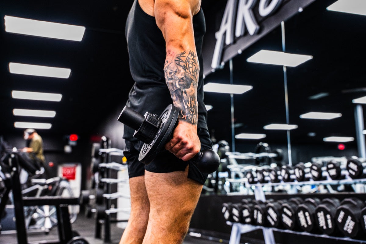 Athlete holding loaded I-Bell in gym environment