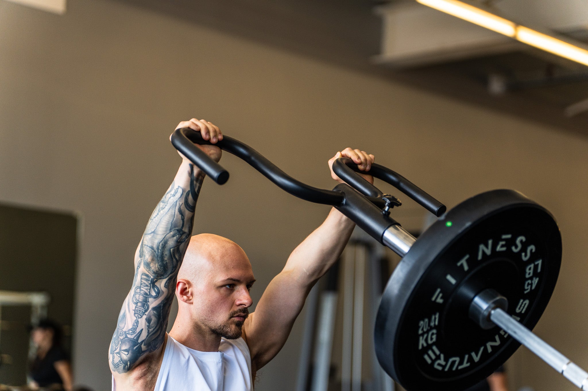 A lifter pressing the Viking Press overhead for upper chest